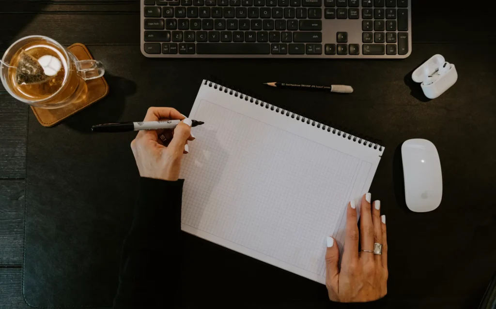 An open notebook, pencil and keyboard arranged for planning